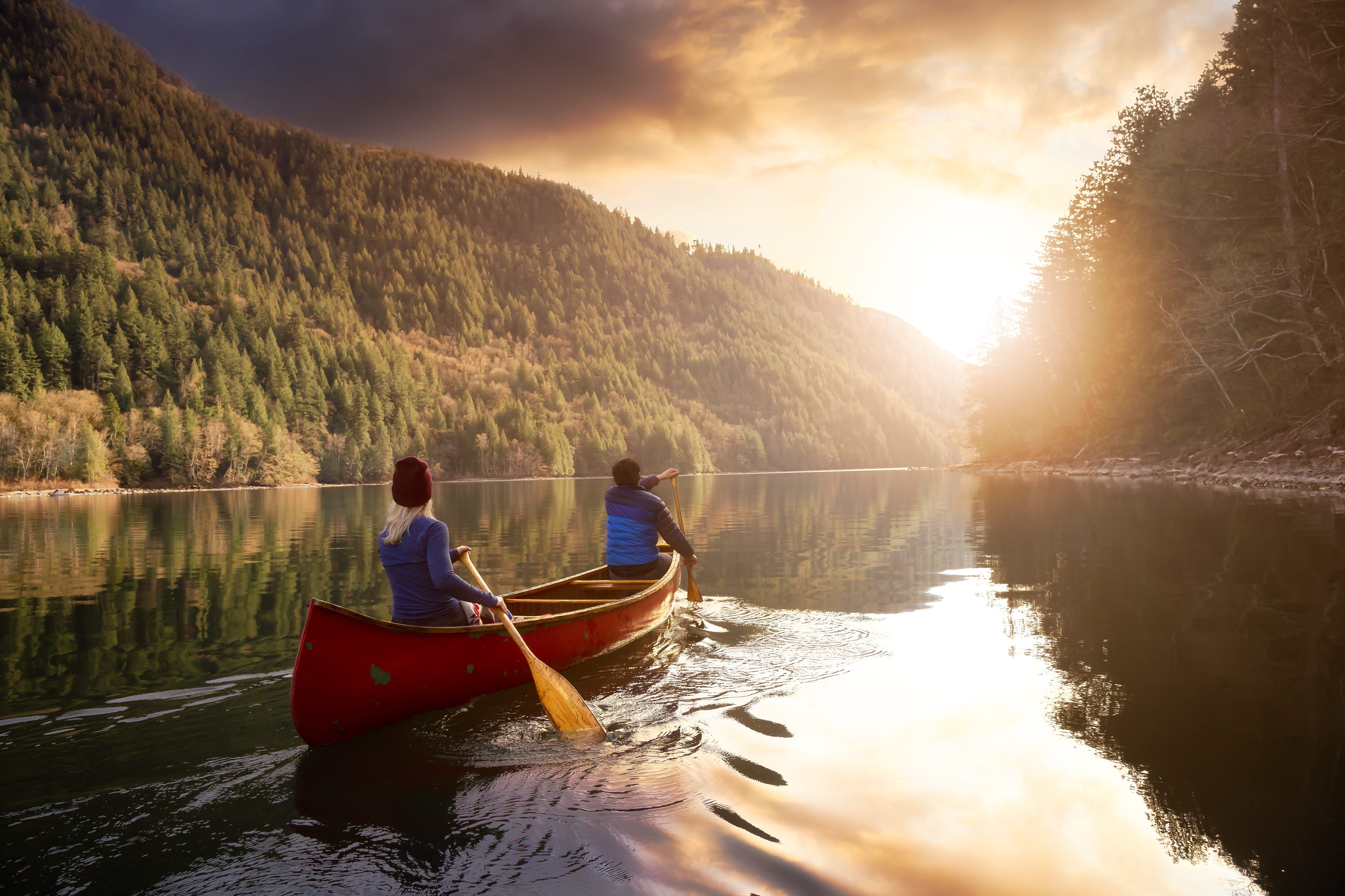 Couple friends canoeing on a wooden canoe Sonata Muziekonderwijs